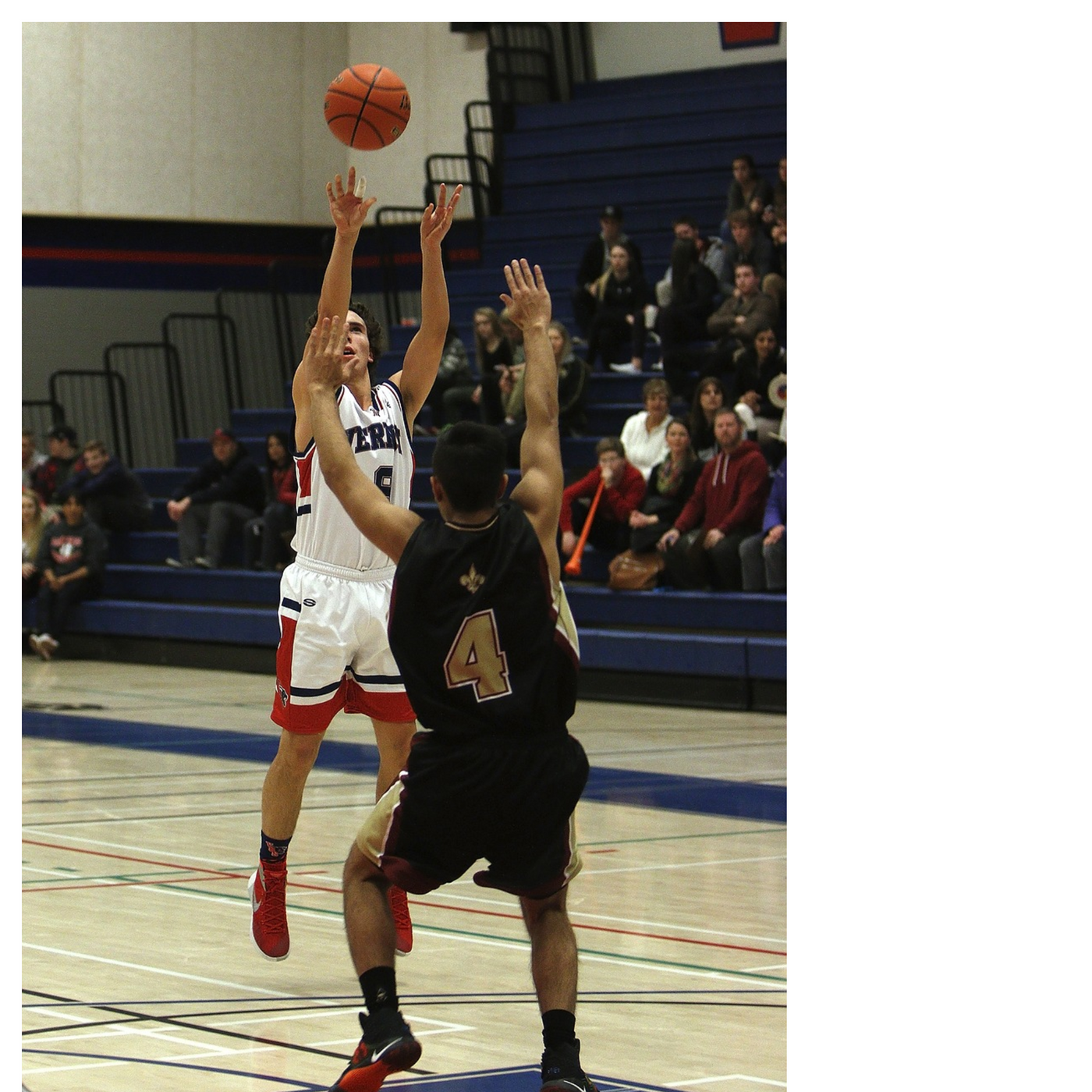 “Basketball player taking a jump shot over a defender in a gym during a game, illustrating real-game shooting situations.”